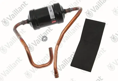 Vaillant Filtertrockner im schwarzen Metallgehäuse mit Kupferrohren. Zubehörteile umfassen eine Schraube und ein schwarzes Montagematerial.